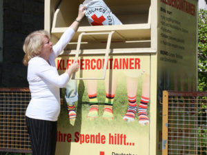 Frau am Kleidercontainer