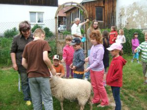 Kinder mit Schaf auf Erlebnishof